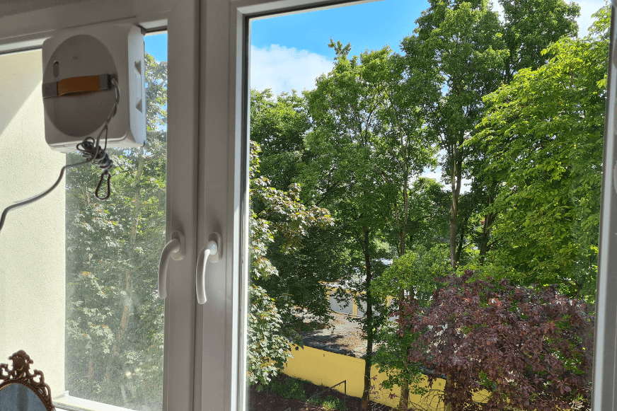 Der Ecovacs Winbot W1 Pro reinigt ein mittelgroßes Fenster im Schlafzimmer